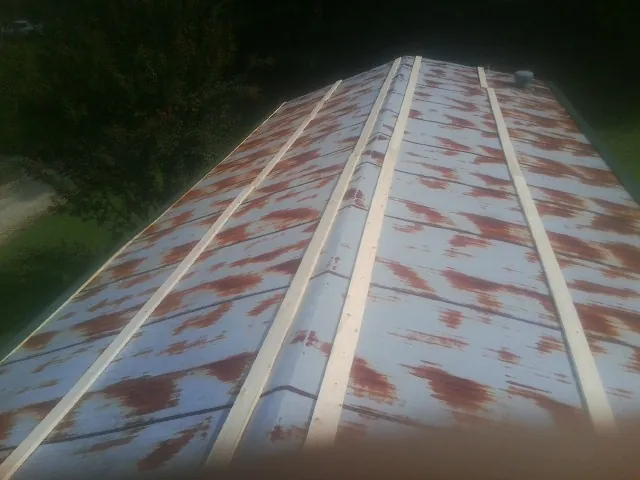 Rusted metal roof panels with new wood purlins before replacement — Storm Damage Roof Repair in Glendale Heights by Roofing Brothers