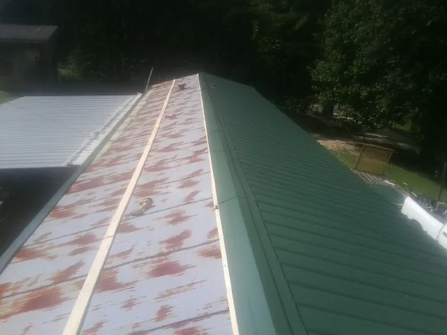Old rusted panels beside newly installed green metal roofing — Wind Damage Roof Repair by Roofing Brothers in Glendale Heights