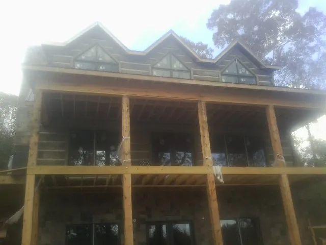 Dormers and porch framing on a large log home under construction — Roof Coating work by our crew in Glendale Heights