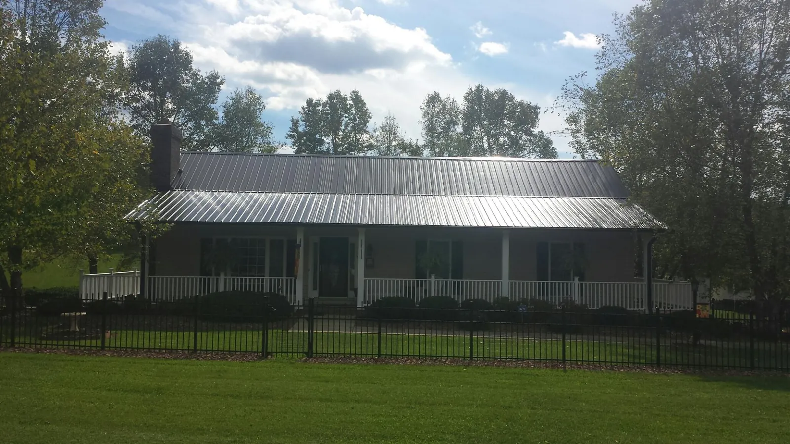 Gray metal roof on a brick ranch with a full width front porch — Gutter Guard Installation work by our crew in Glendale Heights